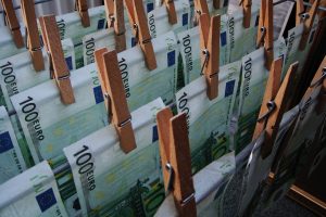 Euro banknotes on a drying rack to represent the criminal activity of money laundering.