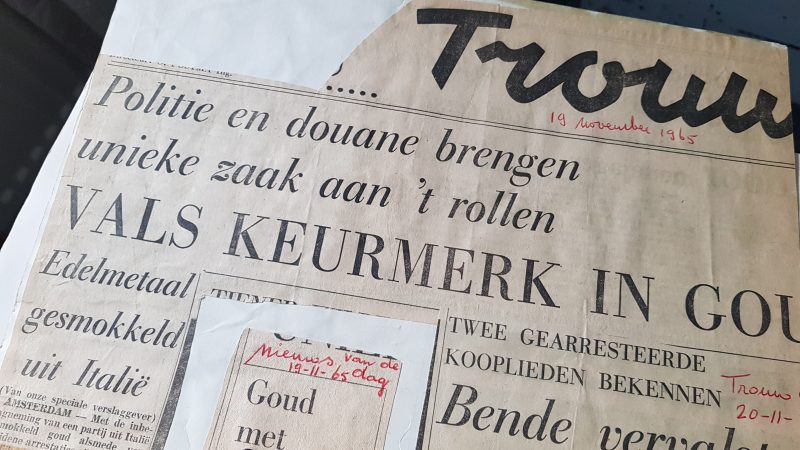 Krantenkop van een knipsel uit de krant Trouw van 19 november 1965: "Politie en Douane brengen unieke zaak aan 't rollen; Vals keurmerk in Goud