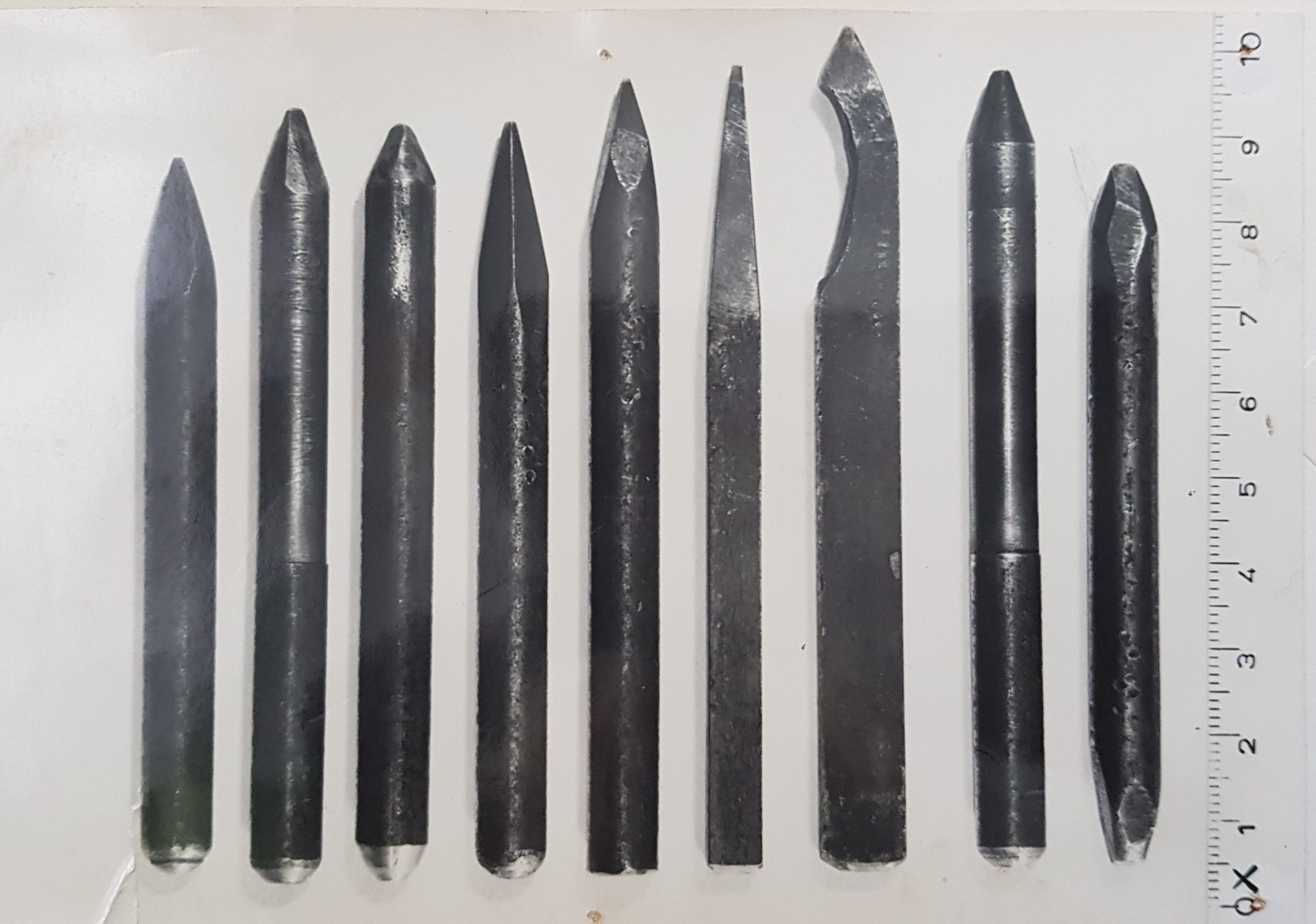 Een zwart wit foto uit 1965 toont 9 metalen staafjes op een witte achtergrond. Helemaal rechts geeft een meetlint aan dat de intstrumenten tussen de 8 en 10 centimeter lang zijn.