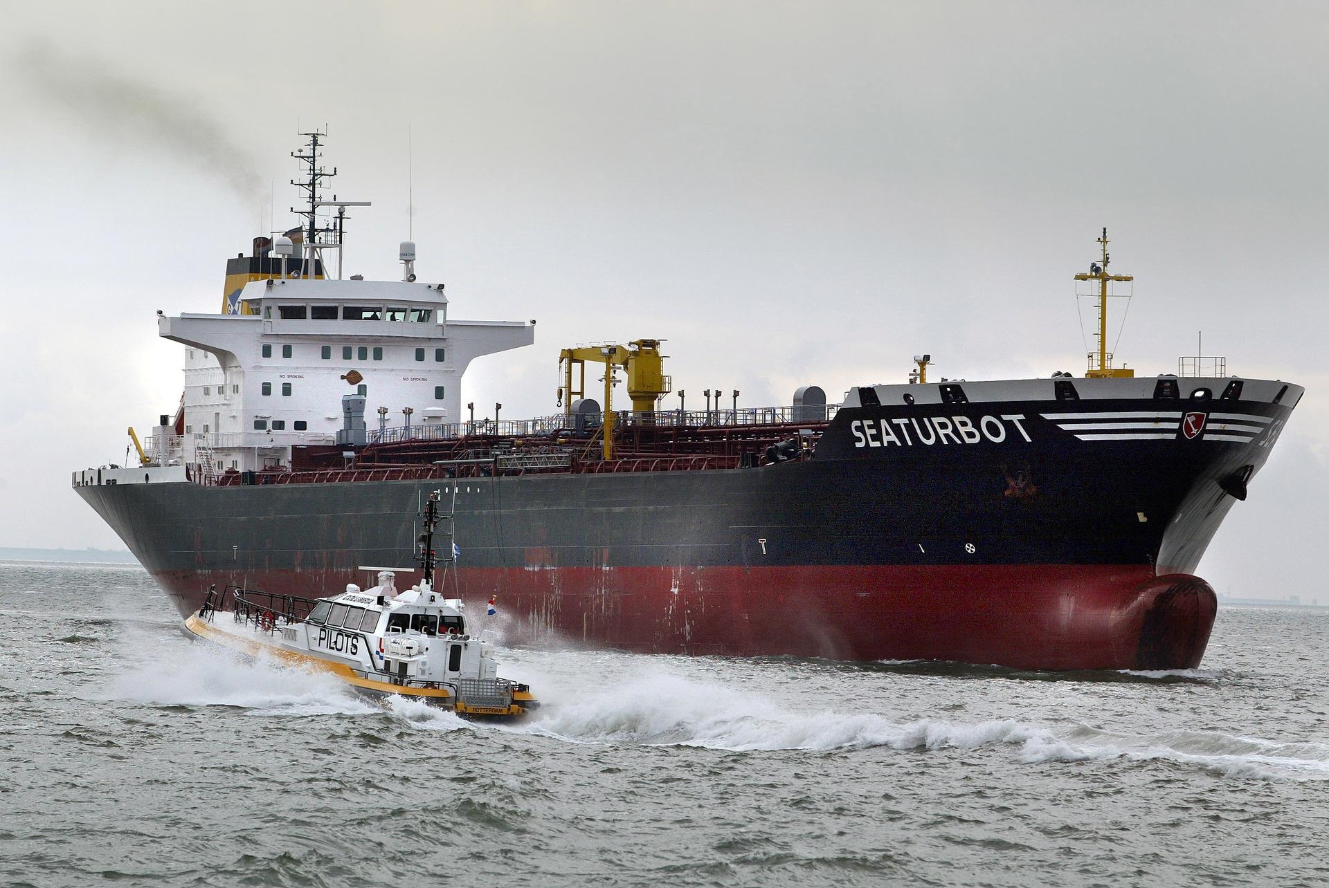 Douaneboot vaart bij zeeschip op de Westerschelde.