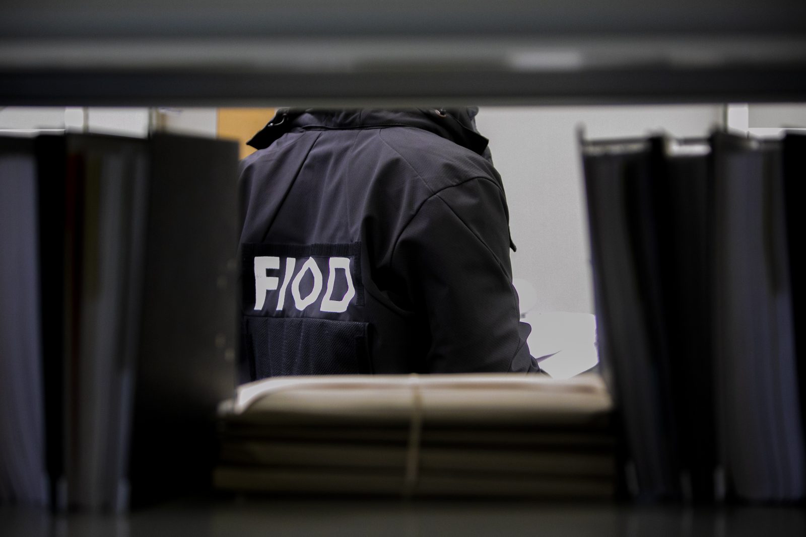 fiodmedewerker bekijkt administratie tijdens inval