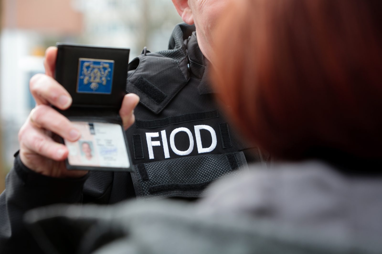 FIOD-medewerker toont FIOD-badge